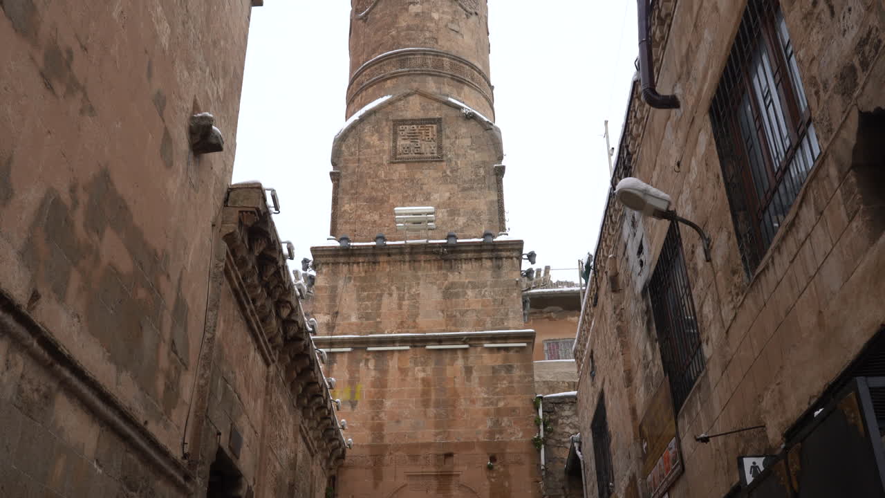 la cámara, colocada en las escaleras que bajan del minarete de la mezquita mardin ulu, revela la magnificencia del minarete al escanearlo de abajo hacia arriba