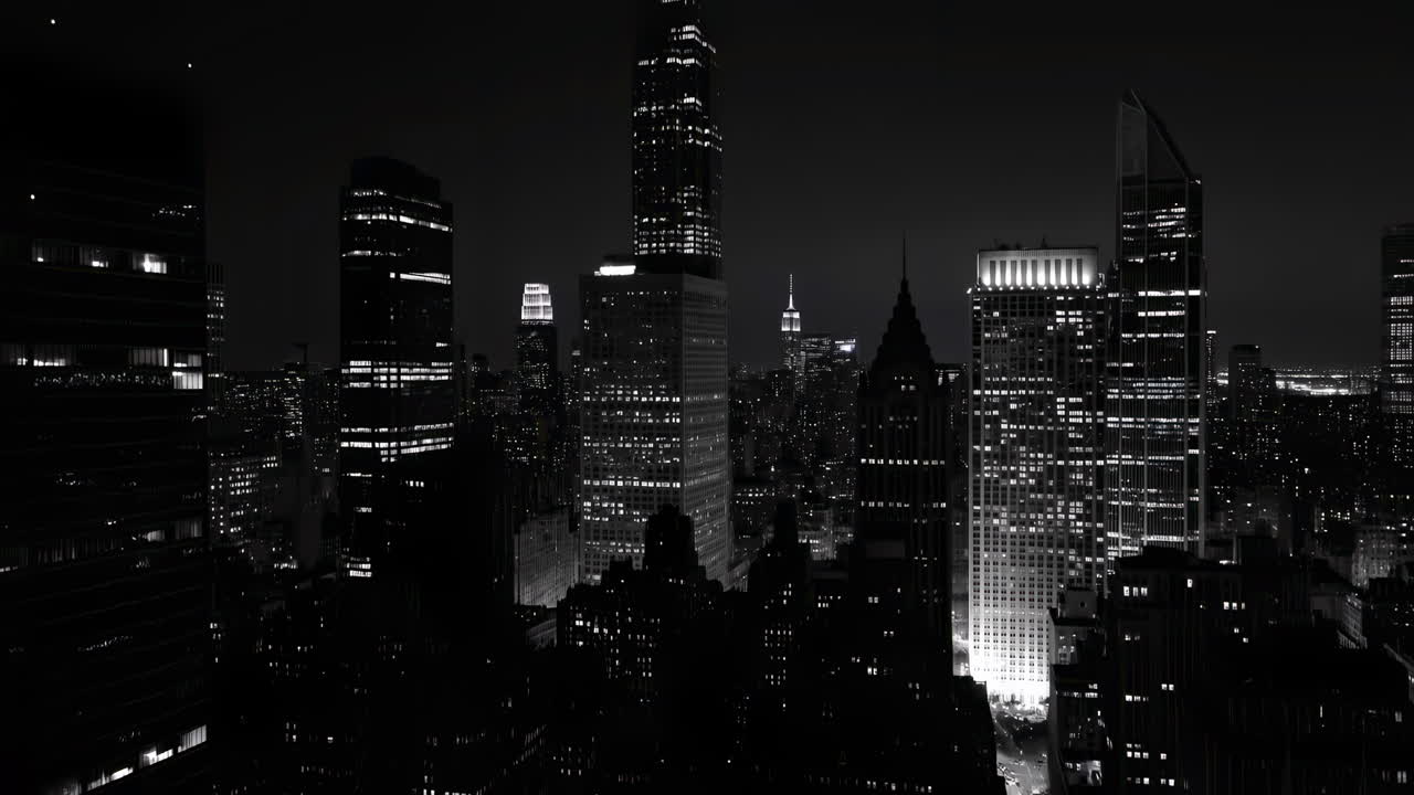 Paisaje Urbano Nocturno en Blanco y Negro con Rascacielos Iluminados y Tráfico