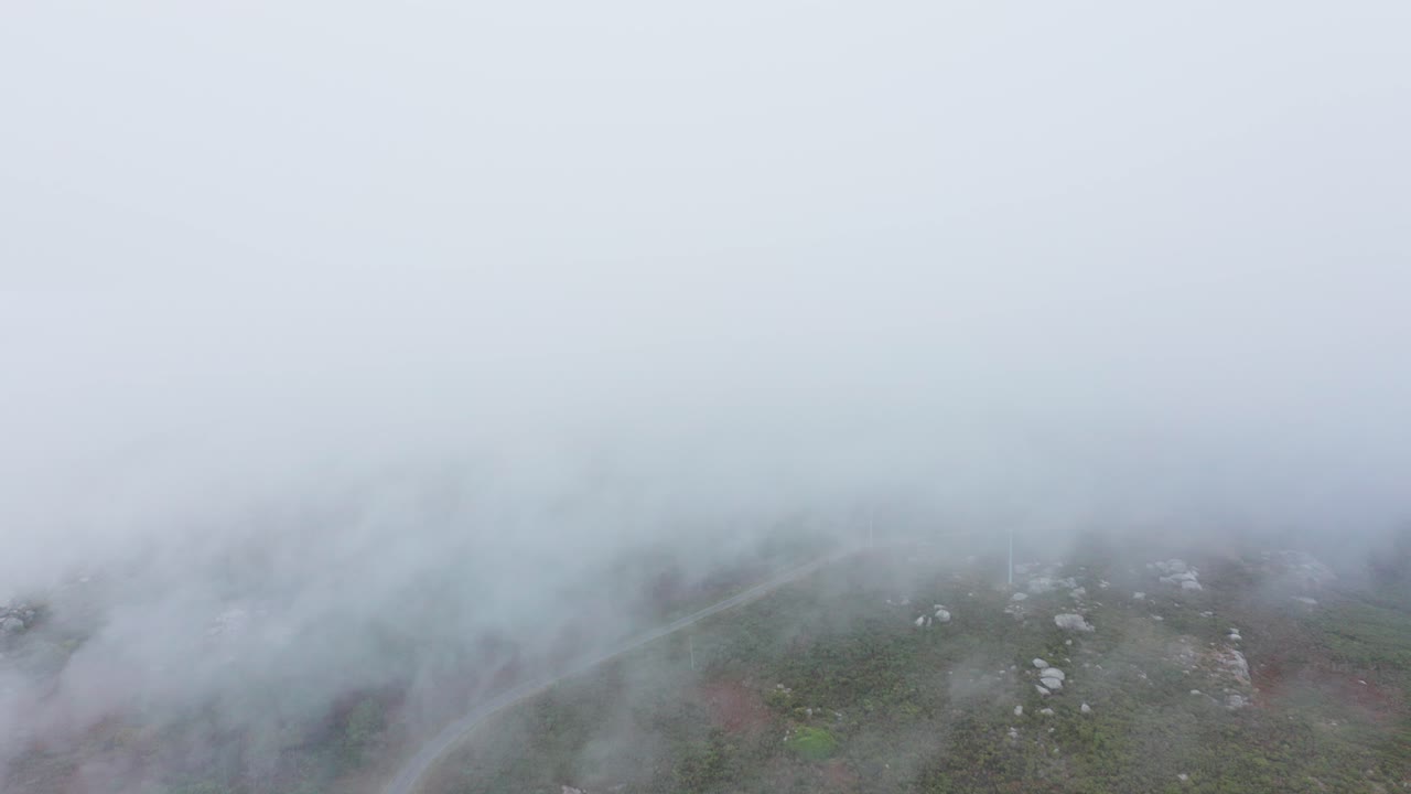 언덕 전망에 고독한 도로와 낮은 구름을 통해 영화 드론 비행