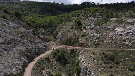 Vista-Aérea-De-Una-Furgoneta-En-Una-Carretera-Rural-En-El-Valle-De-Qadisha,-Líbano,-Disparo-De-Un-Dron-De-Seguimiento