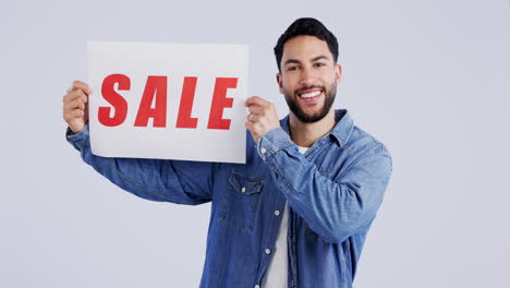 studio portrait of happy man with sale sign