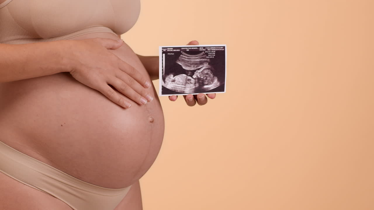 Donna incinta che tiene in mano un'ecografia fetale
