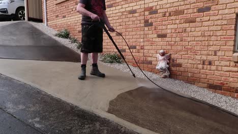 man wearing boot power washing concrete