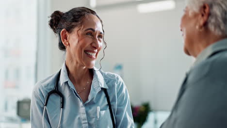 un médico sonriente hablando con un paciente mayor