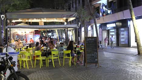 people enjoying food at a street restaurant