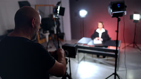 mature man in black t-shirt stands at camera. cameraman recording a video with female blogger.