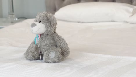 Grauer-Teddybär-Auf-Dem-Bett