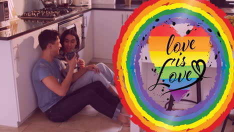 animation of love is love text and rainbow heart over diverse gay male couple talking in kitchen