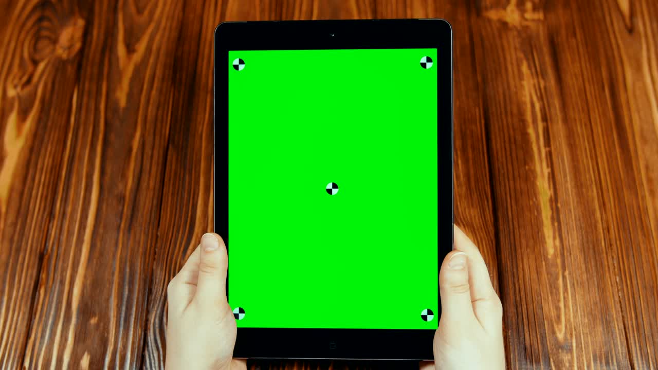 녹색 화면을 가진 수직 태블릿을 사용하는 여성