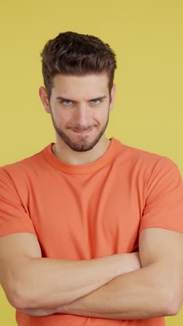 serious man with crossed arms on yellow background
