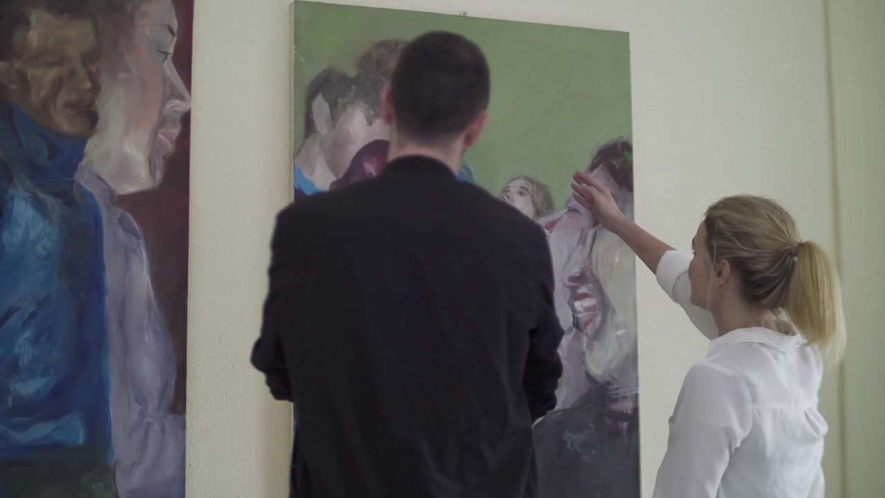 Deux jeunes adultes discutent de tableaux lors d'une exposition d'art. Galerie d'art, étudiants en art.
