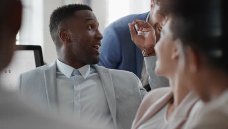 african american businessman chatting with colleagues in office meeting having conversation sharing ideas with diverse corporate group in workplace