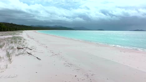 playa de whitehaven drone aéreo islas whitsundays australia sombra nublada lluvia soleada impresionante arena blanca exterior gran barrera de arrecifes azul claro aqua colina del océano entrada de observación turístico movimiento hacia arriba