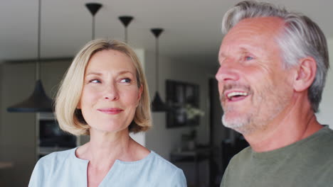 senior couple standing in kitchen and talking together