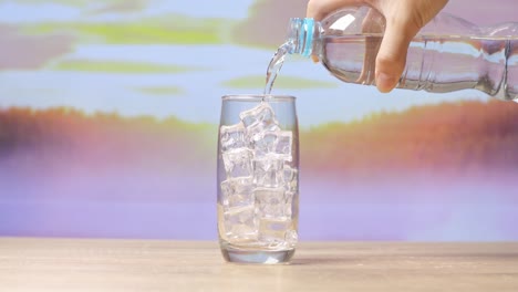 vertiendo agua en un vaso con hielo