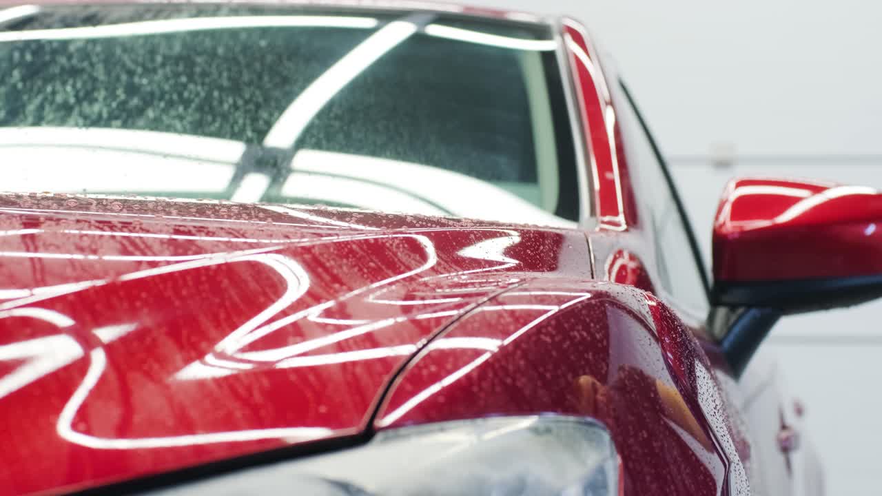 lavado de automóviles limpieza con espuma y agua a alta presión. coche rojo