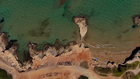 aerial view of rocky coastline meeting sandy beach and turquoise waters in crete