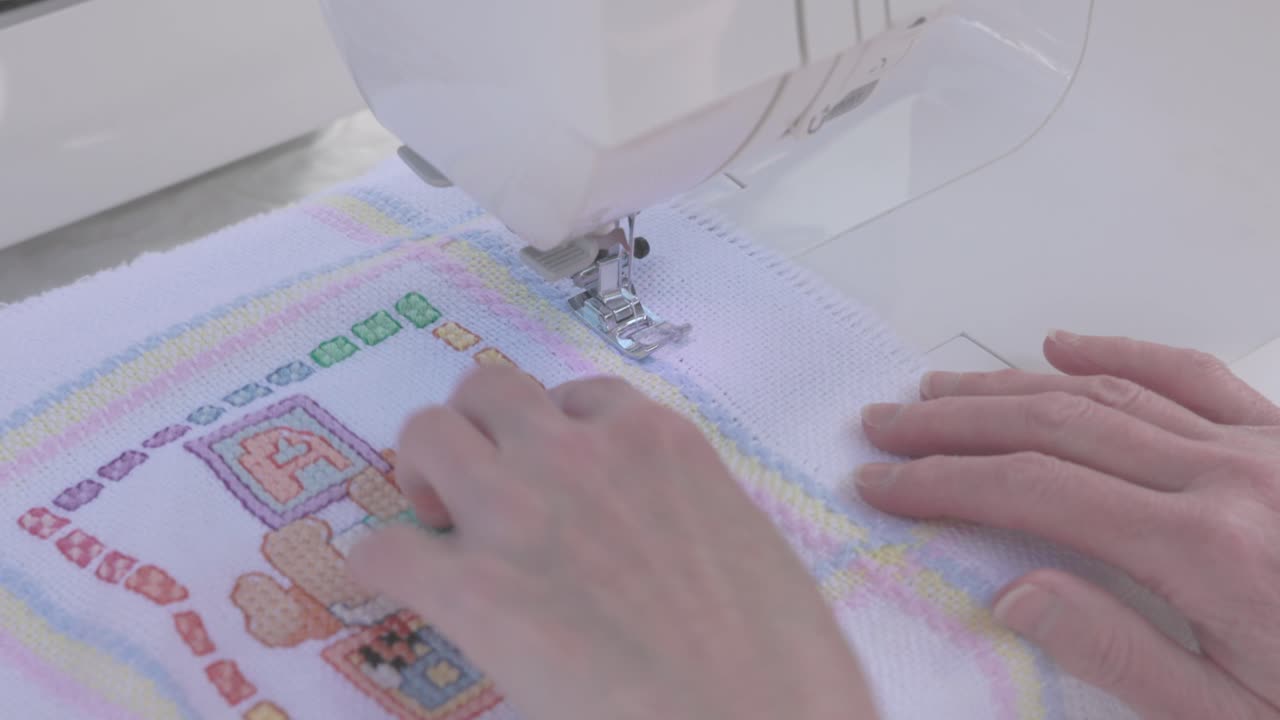 stitching along the border of a baby blanket getting ready to gift