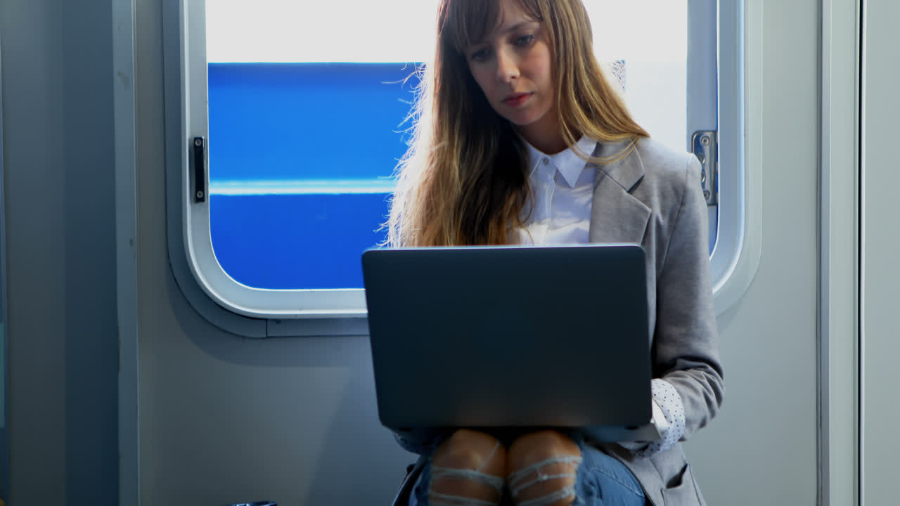 mujer usando una computadora portátil mientras viaja en el ferry 4k