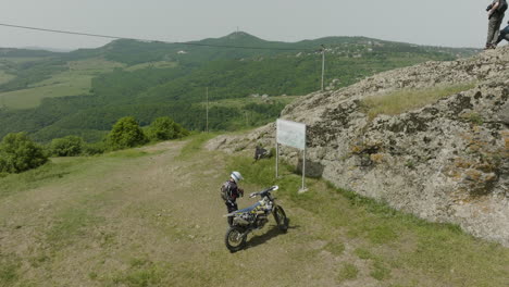 motociclista preparándose para un crucero todoterreno por un valle salvaje y boscoso