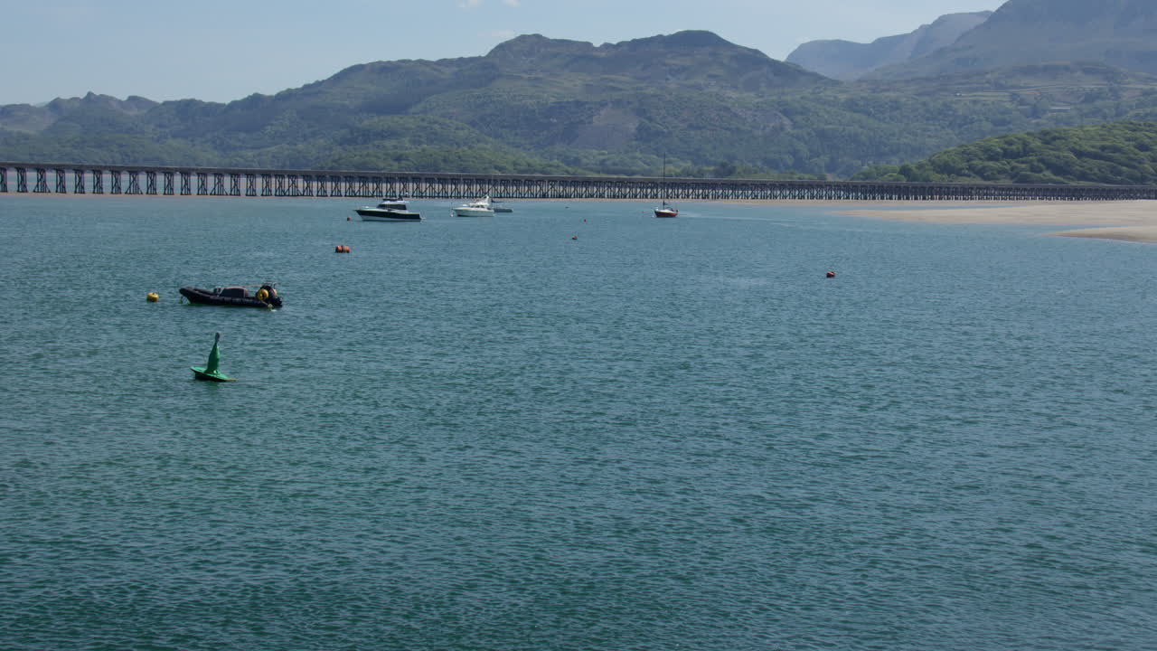 Wide shot of the Barmouth rail bridge and Mawddach estuary looking east