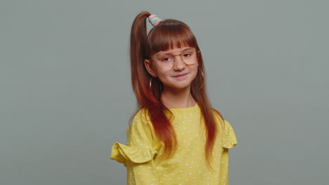 cheerful lovely young preteen child girl kid smiling looking at camera on studio gray background