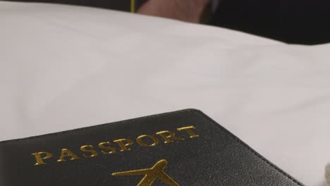 close up of person picking up suitcase and passport ready for summer holiday