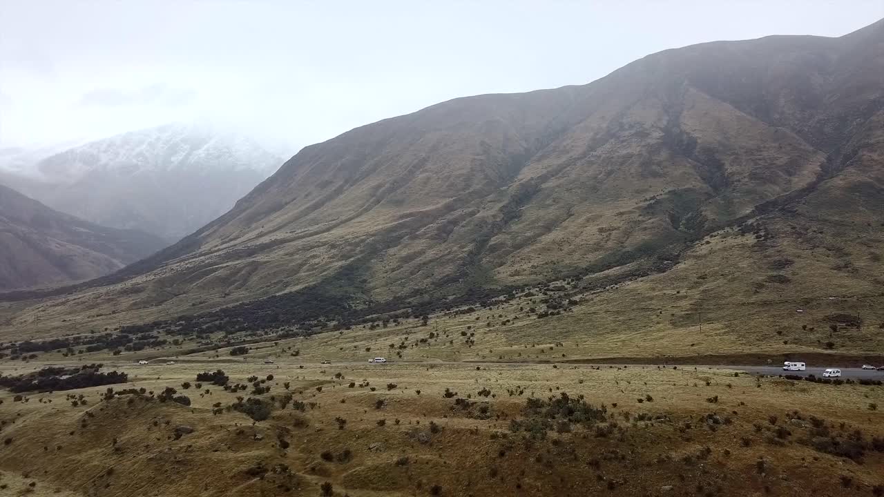 Paesaggio montuoso con strada e veicoli
