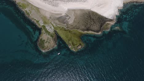 boat sailing by the beautiful shoreline of the patagonian sea -aerial