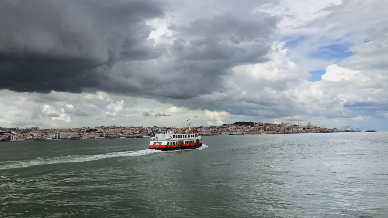 Passenger boat crossing Tagus river, storm heavy clouds