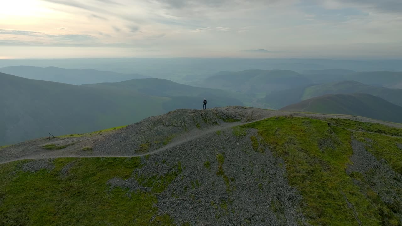 태양이 서기 전에 안개가 가득한 계곡과 산을 드러내는 넓은 느린 도와 함께 정상에 있는 외로운 산책자