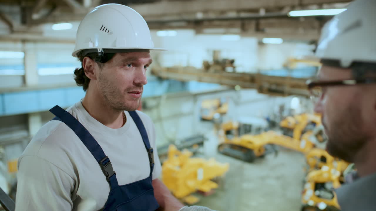 Tecnico che parla con un ingegnere durante la giornata lavorativa in una fabbrica industriale