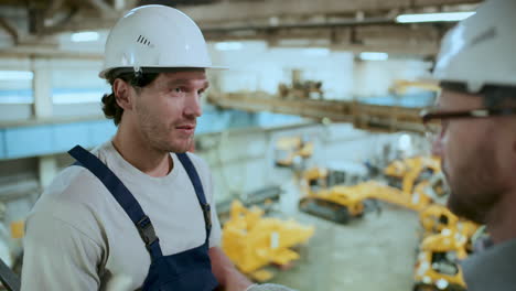 technician talking to engineer during workday in industrial factory