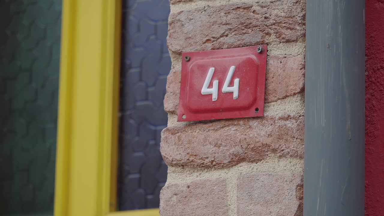 Red House Number 44 on a Brick Wall