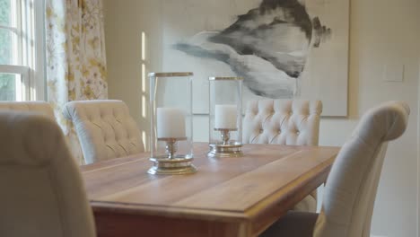 dining room table with white chairs and white candles in a modern luxury home