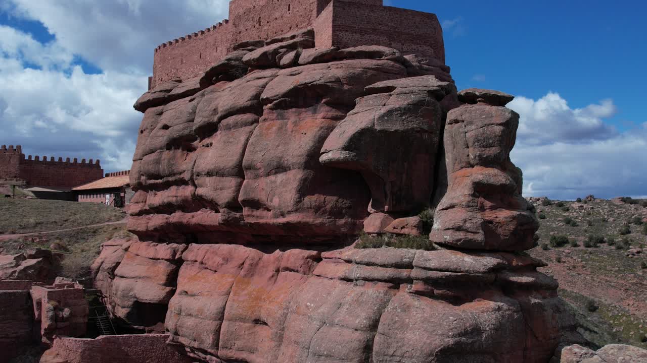Aerial drone view of the Castle of Peracense, in Teruel , built in the X century with red sanstone in the top of a hill with a nice changing sky