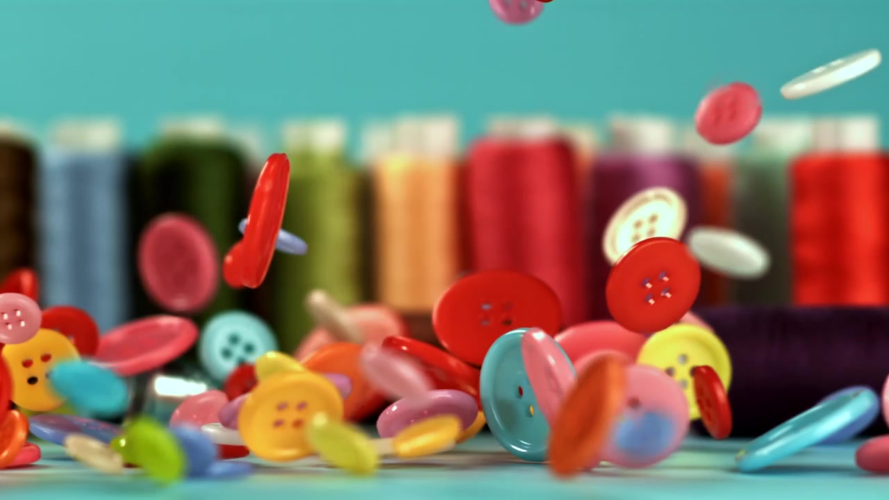 Colorful Sewing Buttons Falling in Slow Motion with Thread Spools