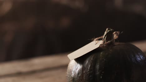 video of halloween pumpkin with tag and copy space on wooden background