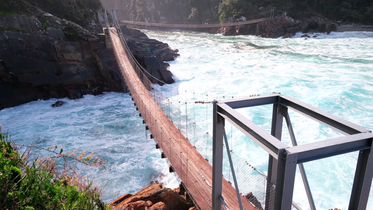 Turbulent waves crash under Tsitsikamma Storms River suspension footbridge