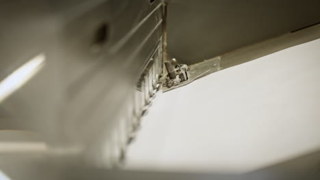 primer plano de la máquina de impresión, papel viajando en la línea de producción, pequeña parte de la máquina en movimiento