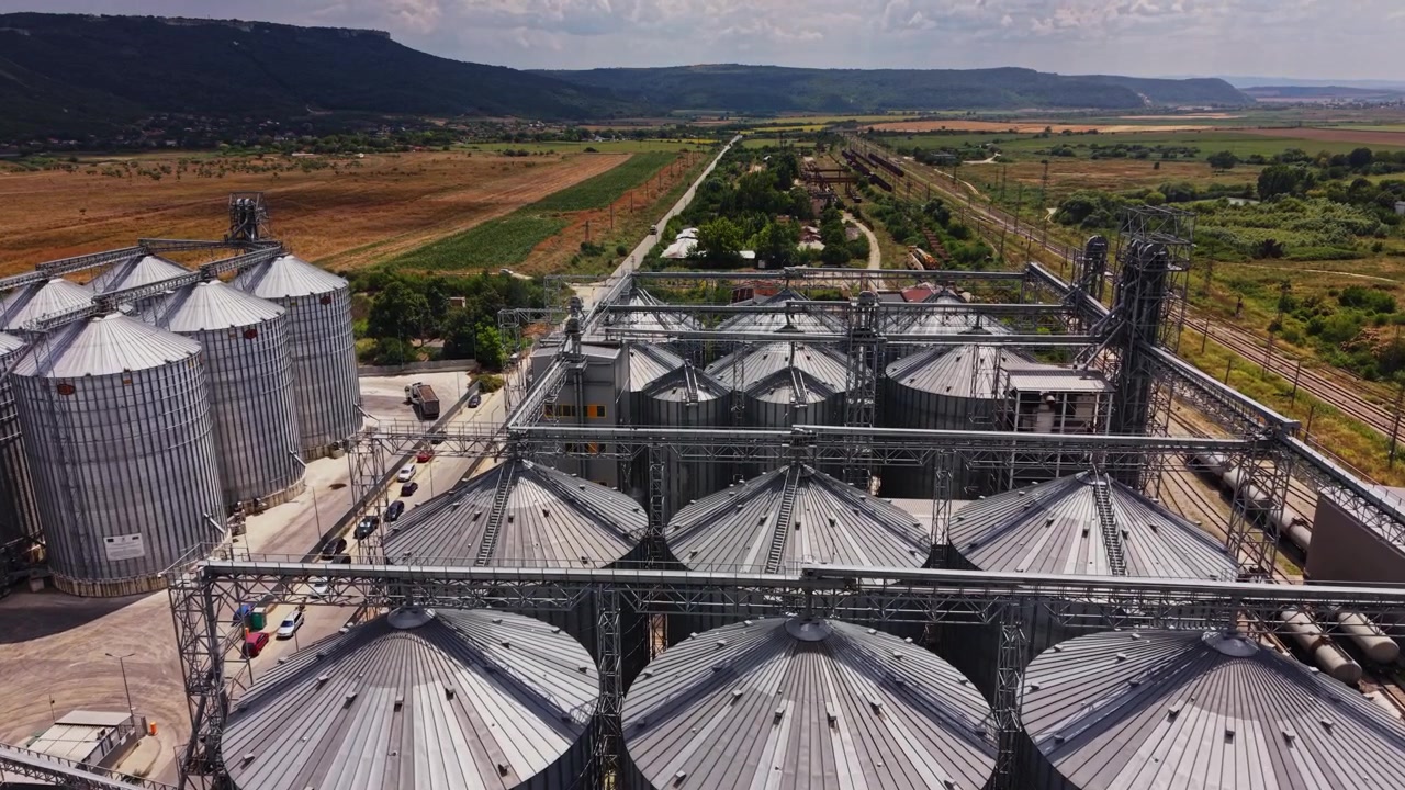 Silos and storage tanks in a farming area with rail access