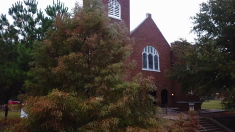 Pan-shot-of-stairs-leading-upto-an-old-brick-church-along-urban-city-in-Tulsa,-Oklahoma,-USA-on-a-cloudy-evening