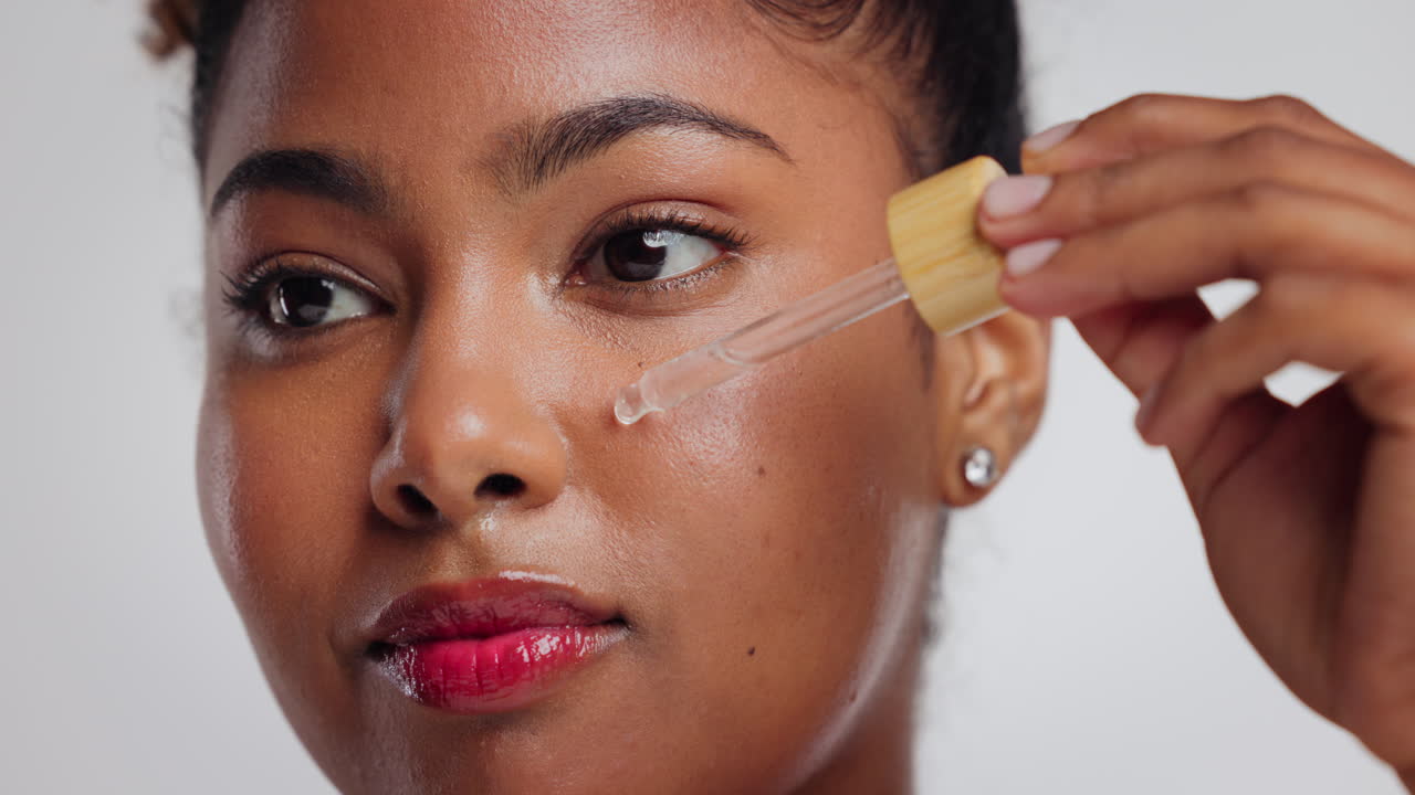 Donna che applica un siero sul viso per la sua routine di cura della pelle