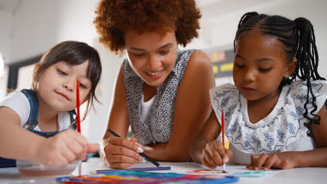 close up of female teacher with multi-cultural elementary school pupils in art class