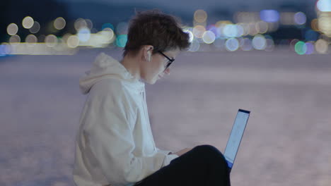 female freelancer working on laptop in the city at night