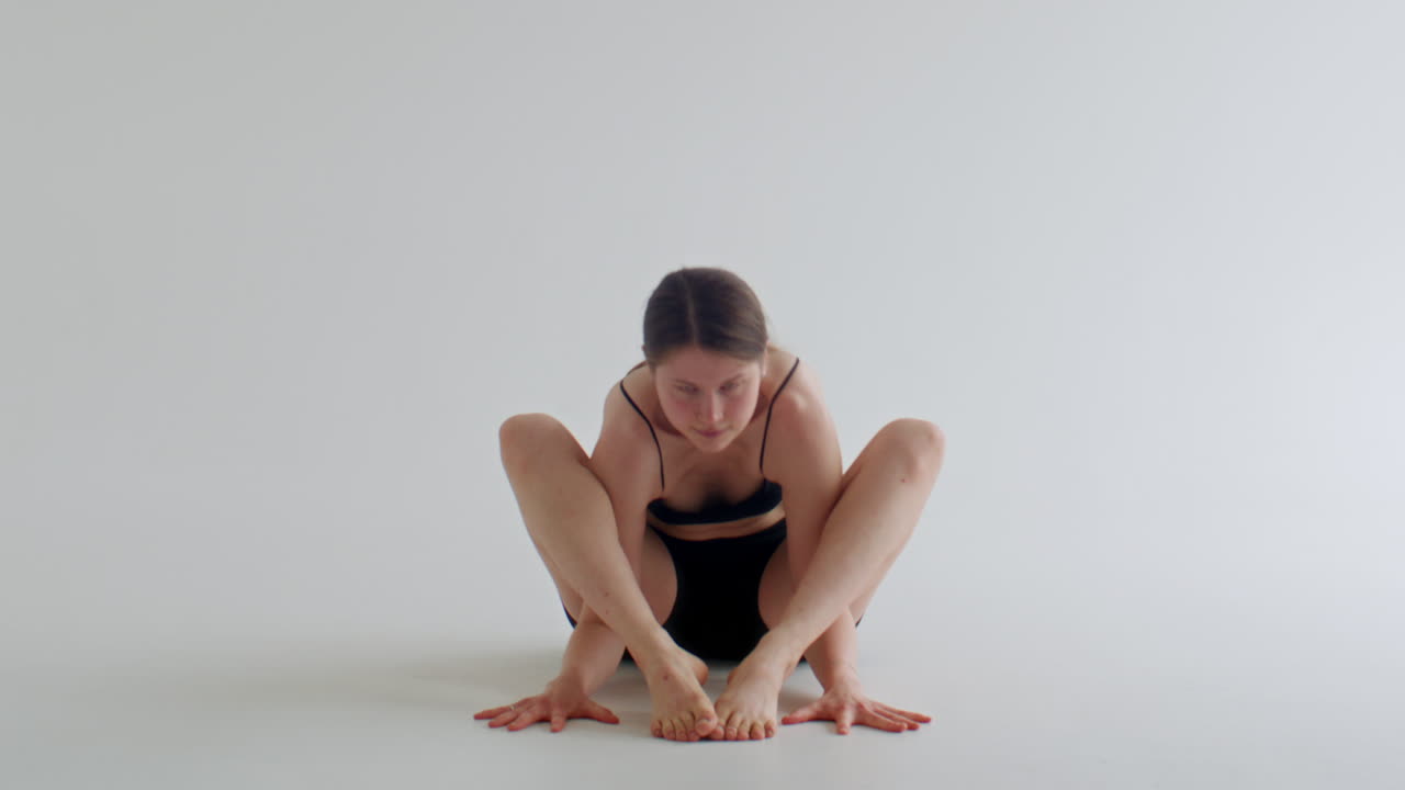 Young Woman Performing Firefly Pose during Yoga Practice in Studio