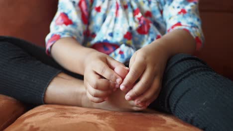 niño inspeccionando los dedos de los pies