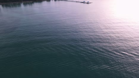 Panorámica-Aérea-De-Drones-Sobre-Aguas-Azules-Tropicales-Hasta-El-Muelle-Durante-El-Amanecer