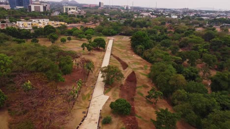beautiful aerial of the famous millennium park in abuja, nigeria. a long path runs through the green park filled with trees in the african capital city