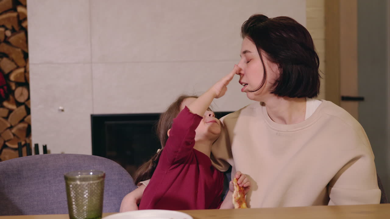 Mother and Daughter Enjoying Pizza Dinner